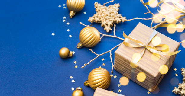 istock Christmas composition with golden gift box and christmas decorations, garland on a blue background. Winter holiday background with copy space 1754572145