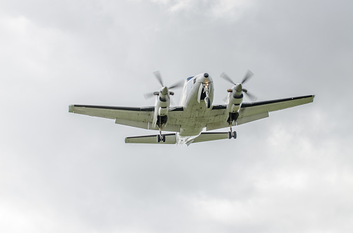 Propeller plane flying on the cloudy sky background