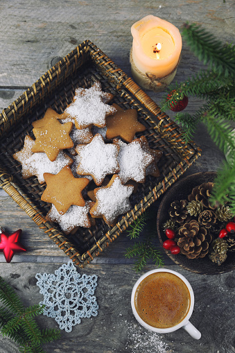 Christmas cinnamon cookies (spice-cake),  cup of coffee and New Year's decoration. Rustic style, toned image, top view