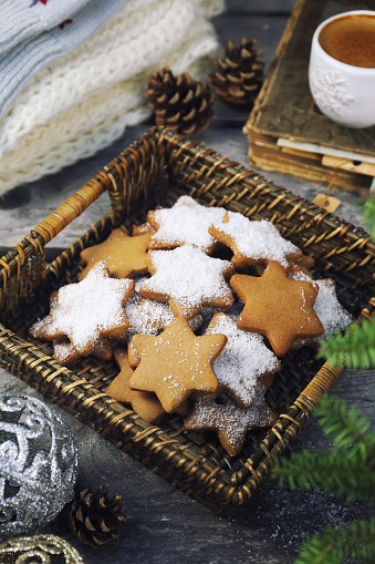 Christmas cinnamon cookies (spice-cake),  cup of coffee and New Year's decoration. Rustic style, toned image