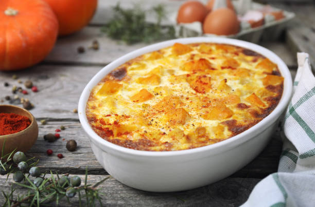 French cuisine. Vegetable pumpkin clafoutis in ceramic bakeware, smoked paprika dressing