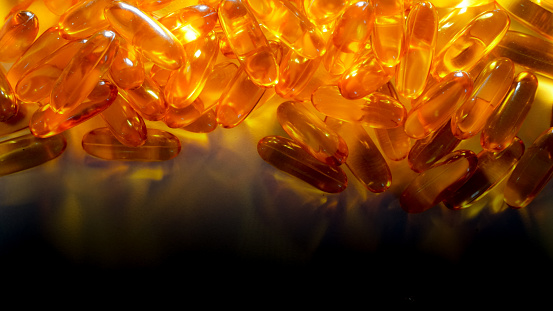 Medicine in gelatin capsules on a shaded background