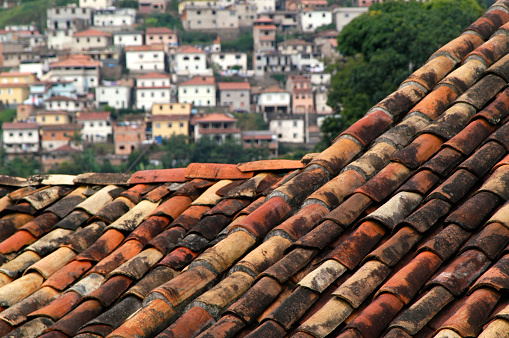 Traditional South American terra cotta red clay roof foreground with hillside community in the background