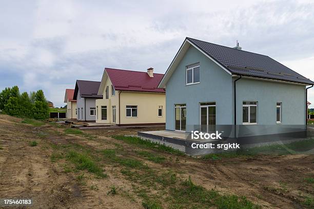 Photo libre de droit de Nouveau Cottages Avec Herbe Verte À Proximité De La Route banque d'images et plus d'images libres de droit de Bâtiment vu de l'extérieur