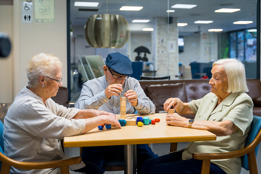 elderly residents in a nursing home engaging in motor skills games with pieces