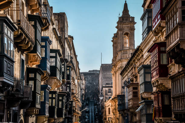 Old Mint Street Teeming With Bay Windows And St. Dominic Basilica In Valletta, Malta