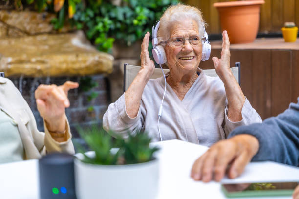 Happy seniors listening to his favorite music in a geriatric Happy seniors using headphones while listening to his favorite music in a geriatric old person listening to radio stock pictures, royalty-free photos & images