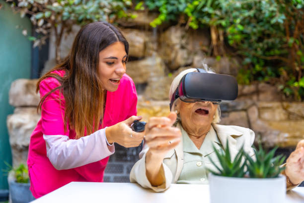 istock Nurse and woman using Virtual Reality goggles in a geriatric 1754628506