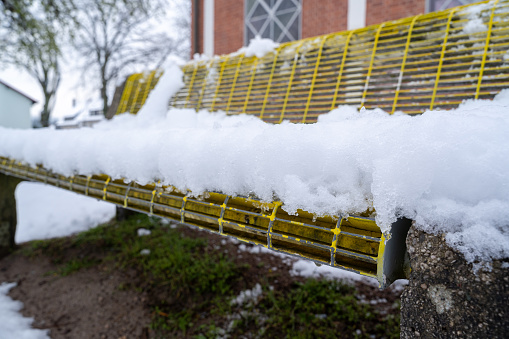 Yellow park bench with snow in winter