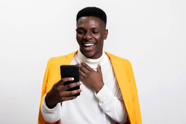 istock Good-looking happy attentive man using device to chat during his free time standing alone against a bright blue background 1754629408