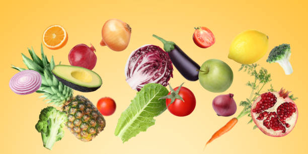 istock Many fresh vegetables and fruits falling on gold background 1754649644