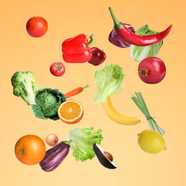 istock Many fresh vegetables and fruits falling on light orange background 1754650784