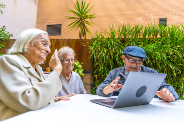 persone anziane che usano la tecnologia in una casa di cura - senior adult surfing aging process sport foto e immagini stock