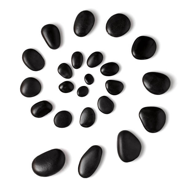 Spa stones A spiral of black massage stones on white background stone object stock pictures, royalty-free photos & images