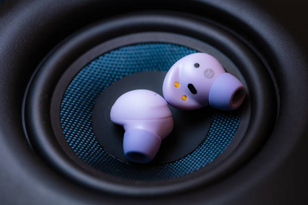 istock wireless earpone buds on speakers background 1754685709