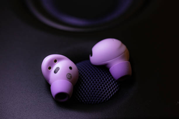 istock wireless earpone buds on speakers background 1754685923