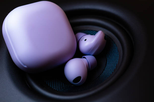 wireless earpone buds on speakers background