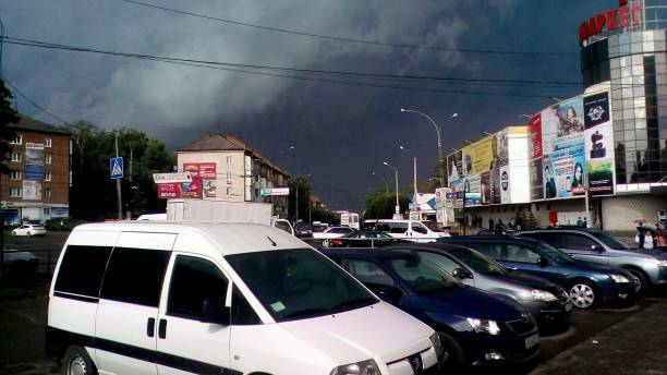 samochody na parkingu, chmura burzowa w tle - donchangan jie zdjęcia i obrazy z banku zdjęć