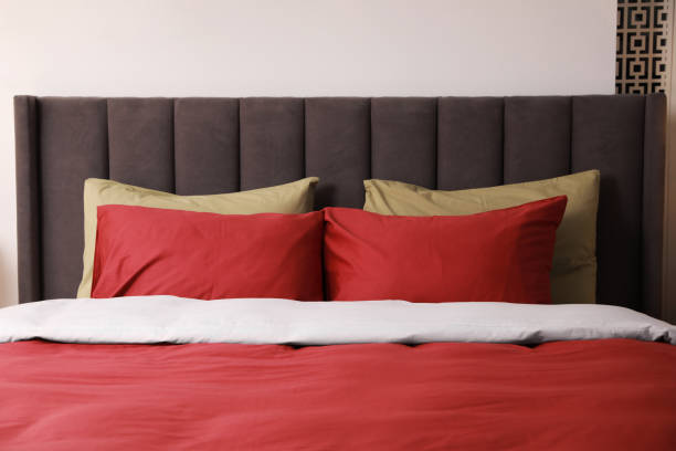 istock Comfortable bed with cushions in room. Interior design 1754718324