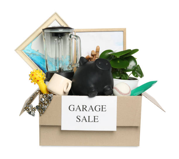 istock Different stuff in box with sign Garage Sale isolated on white 1754718336