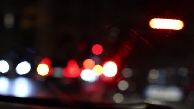 Blurred windshield background with flickering bokeh.