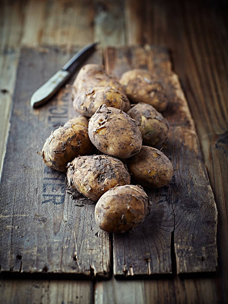 istock New potatoes on old wooden background 175473243