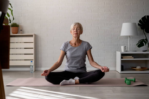 istock Active elderly woman practicing yoga indoors 1754751704