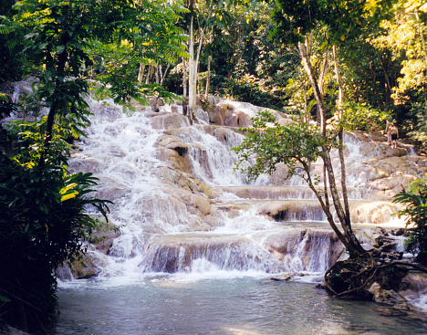 Dunn 's River Falls are waterfalls in Ocho Rios, Jamaica. The water overcomes a height difference of 55 meters over a distance of 180 meters. The Dunn's River Falls are one of the world's very rare waterfalls that flow directly into the sea.
