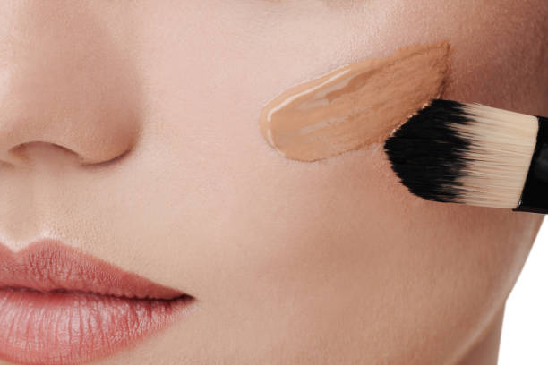 istock Woman applying foundation on face with brush, closeup 1754761048