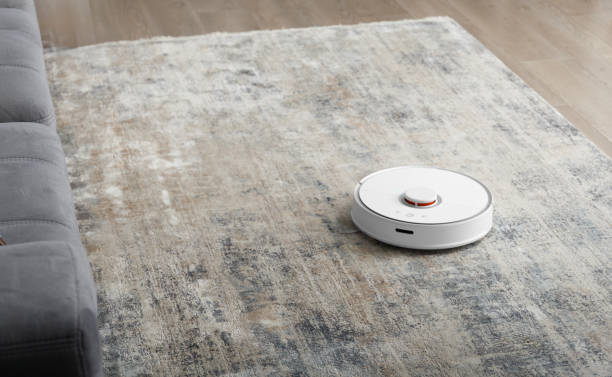 istock Modern robot vacuum cleaner on soft carpet in room 1754761686