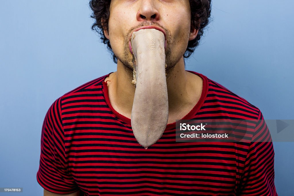Mann mit einer Kuh in seinem Mund die Zunge - Lizenzfrei Rinderzunge Stock-Foto