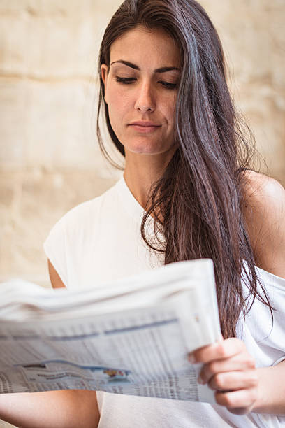 istock Smiling woman on the city reading newspapers 175478295