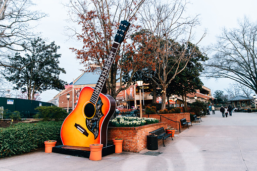 Nashville, TN, USA - February 27, 2018: The Grand Ole Opry is one of the most famous music venues since being created in 1925. The area around it is filled with guitars, a food truck and seating.