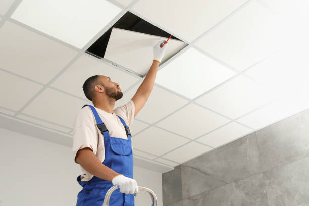 istock Electrician with screwdriver repairing ceiling light indoors, low angle view. Space for text 1754783917