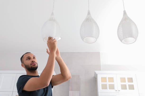istock Young man repairing ceiling lamp indoors, space for text 1754783927