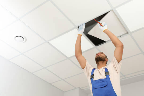 istock Electrician with screwdriver repairing ceiling light indoors, low angle view. Space for text 1754784485