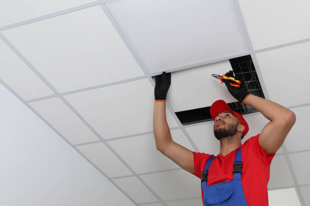 istock Electrician with pliers repairing ceiling light indoors, low angle view. Space for text 1754785039