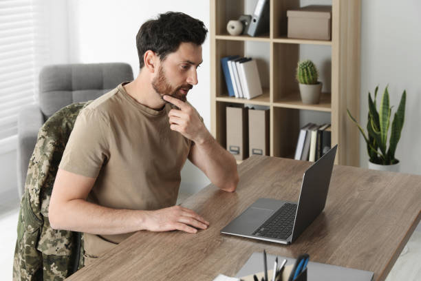 istock Soldier using laptop at wooden table indoors. Military service 1754786664