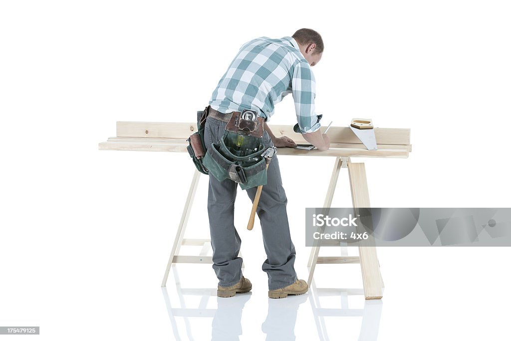 Carpentiere lavora su un cavalletto - Foto stock royalty-free di Carpentiere
