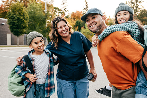 Health care professional with husband picking  up their  kids from school