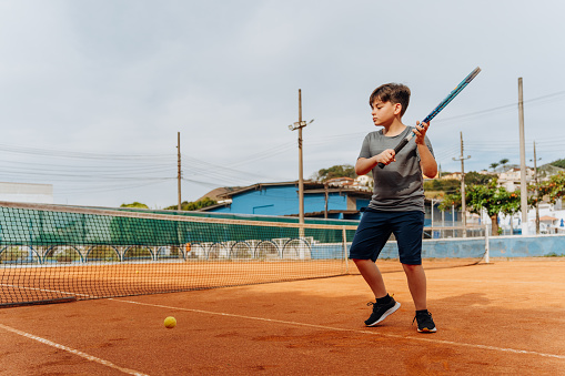 Boy during tennis lesson on the court