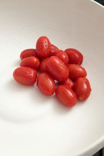 wet cherry tomatoes in white ceramic bowl