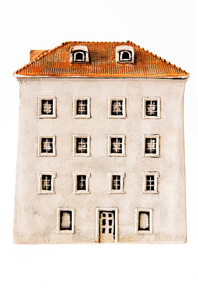 Front view of miniature apartment block building made from clay isolated on white background, my own artwork, full frame vertical composition
