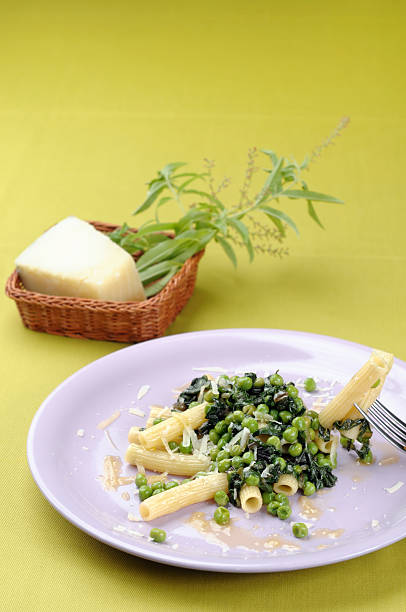 Sedani pasta with peas, lettuce and cheese "Sedani pasta with peas, lettuce and pecorino cheeseItalian cuisine" pecorino romano stock pictures, royalty-free photos & images