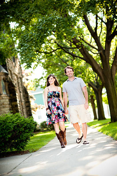 istock Happy Couple Holding Hands and Walking Along Sidewalk Together Outside 175481738