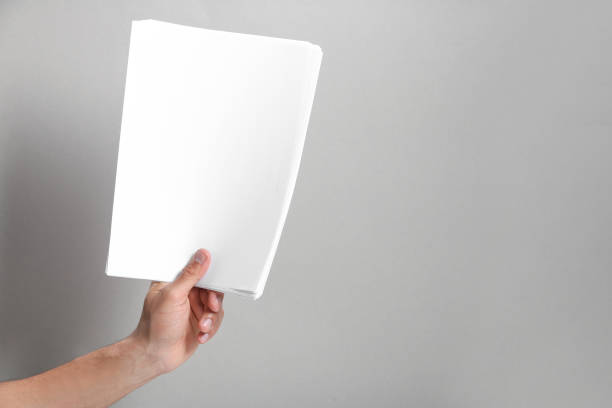 istock Man holding sheets of paper on grey background, closeup. Mockup for design 1754819471