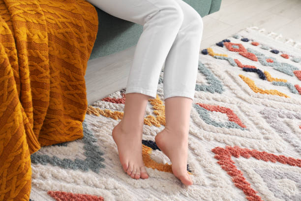 istock Woman on carpet with pattern at home, closeup 1754819996