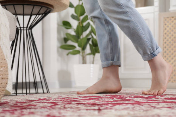 istock Woman standing on carpet with pattern at home, closeup. Space for text 1754820512