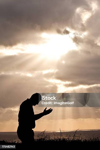 Medio Invecchiato Uomo Di Pregare Contro Cielo Minaccioso - Fotografie stock e altre immagini di Inginocchiarsi