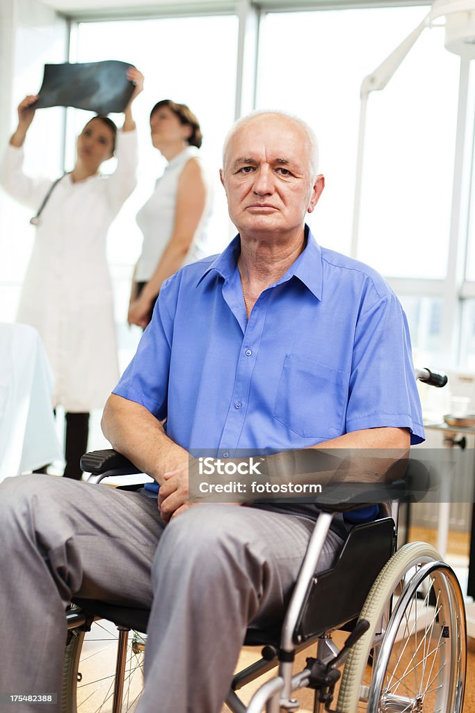 Homem em cadeira de rodas, médico, olhando para a imagem de raio-x - Foto de stock de 50 Anos royalty-free
